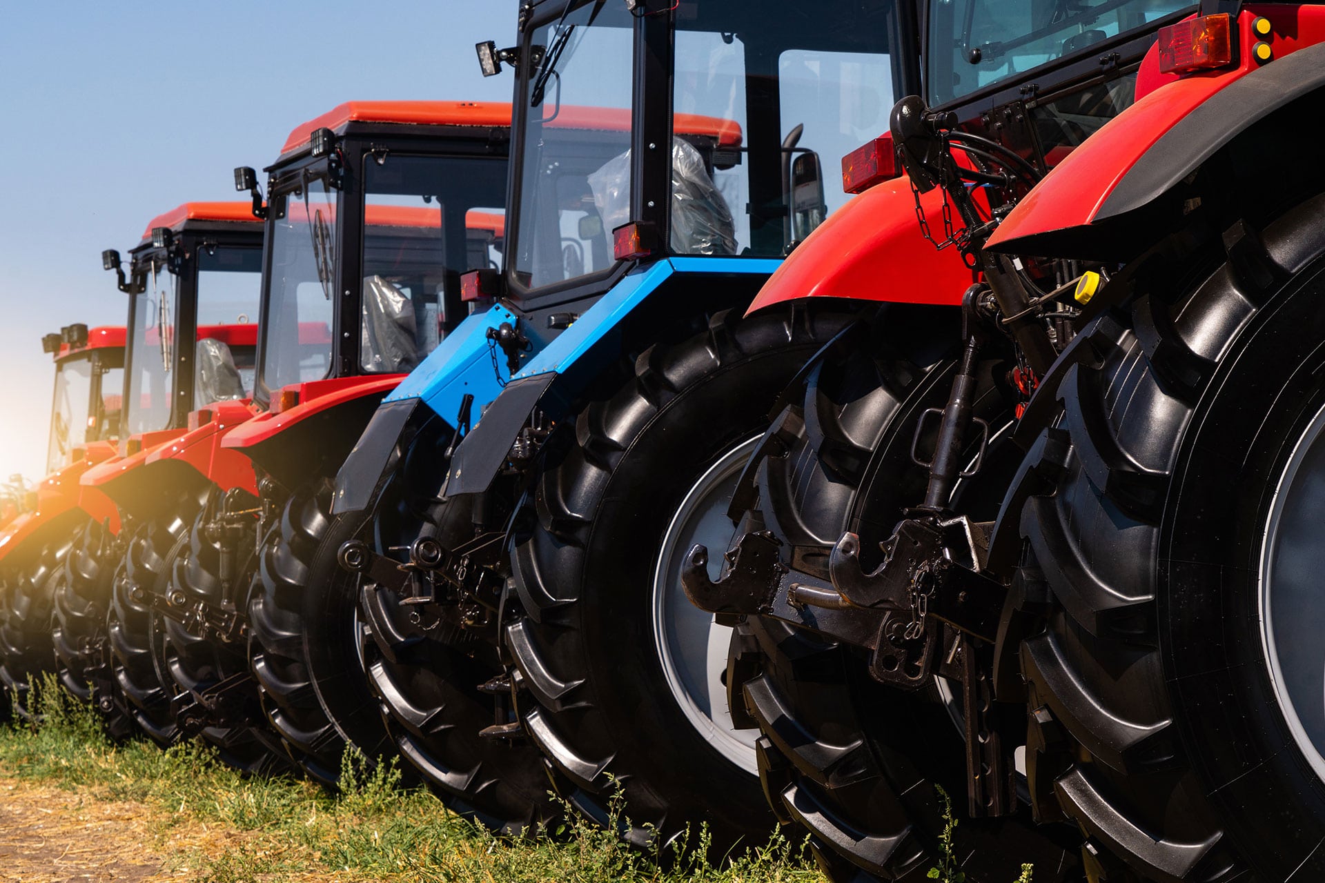 A line of several blue and red tractors